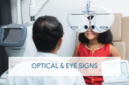 An optometrist adjusts the phoropter while conducting an eye exam. The space bears a Chassis exam room 1 sign.