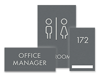 Three sign types from the Aleigha sign collection: a door plate for OFFICE MANAGER, a restroom sign, and a room number sign with 1-line insert