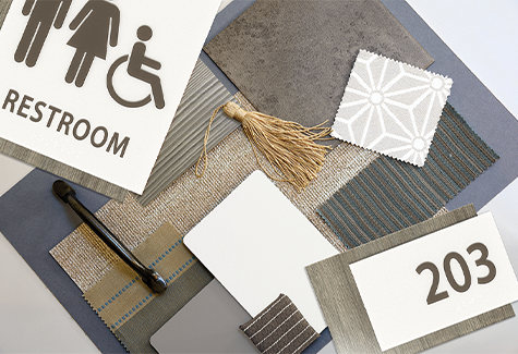 Assisted living signage mood board with restroom and room number signs, fabric swatches, and hardware