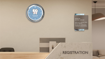 A dental office registration desk with branded wall signage and patient check-in signage.