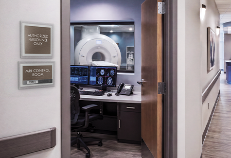 MRI control room sign with in-use status slider and authorized personnel sign outside a radiology suite.